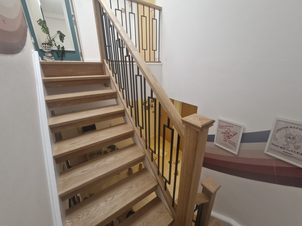 Oak handrail and newel posts with contemporary black metal spindles